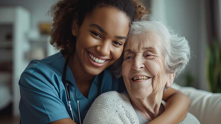 Family members sit beside an older adult during a small assisted living activity in a bright community room.