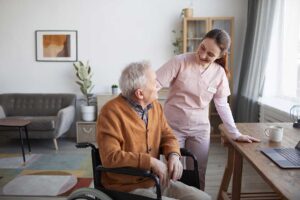 Older adults in a bright activity room practice seated stretching with a caregiver.